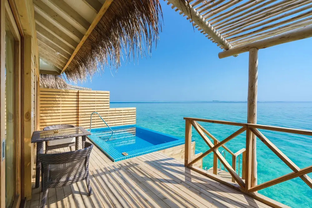 Overwater villa with a private pool above clear blue water